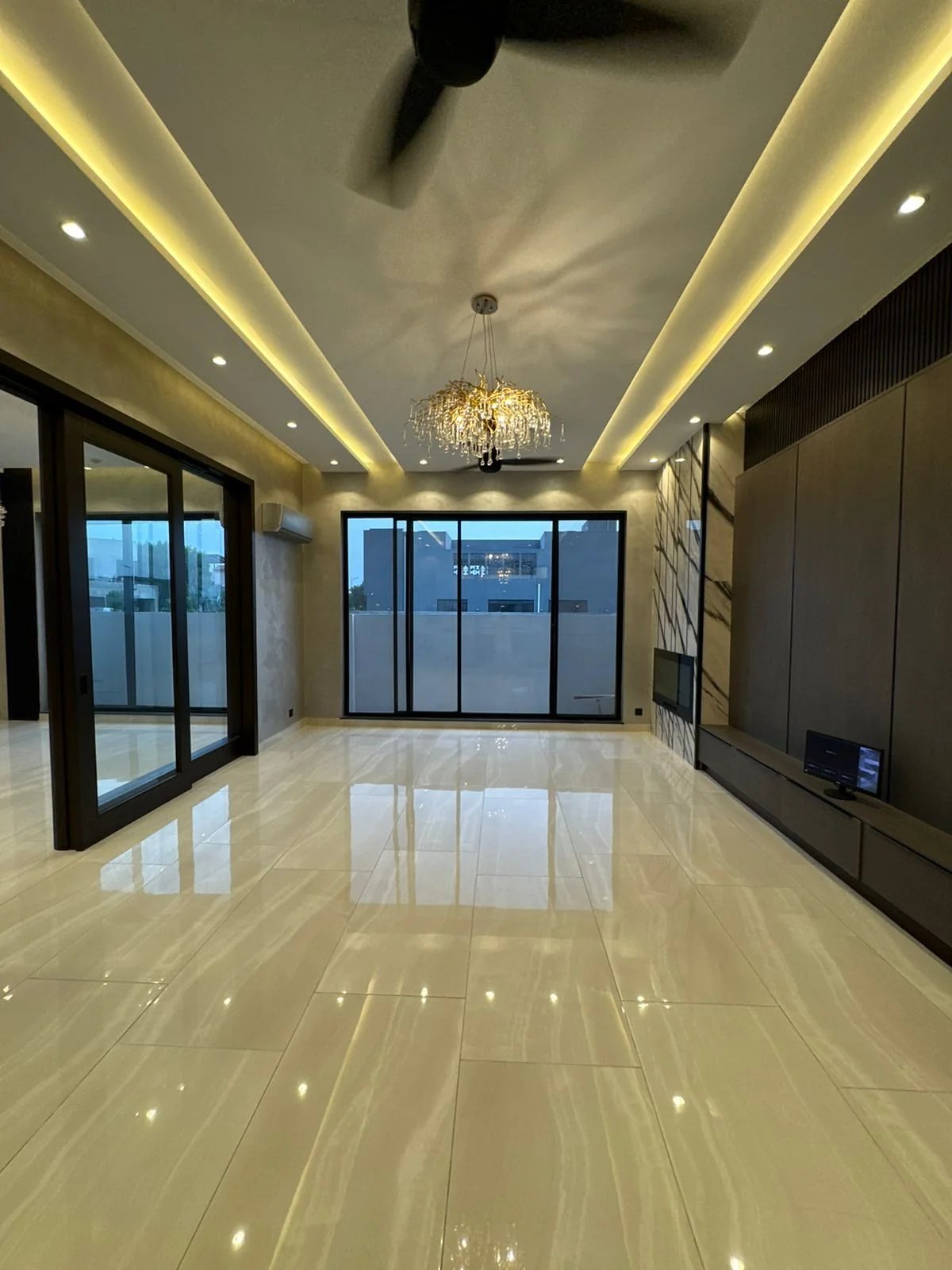 Modern villa living room with gold chandelier and decorative accent wall Dubai