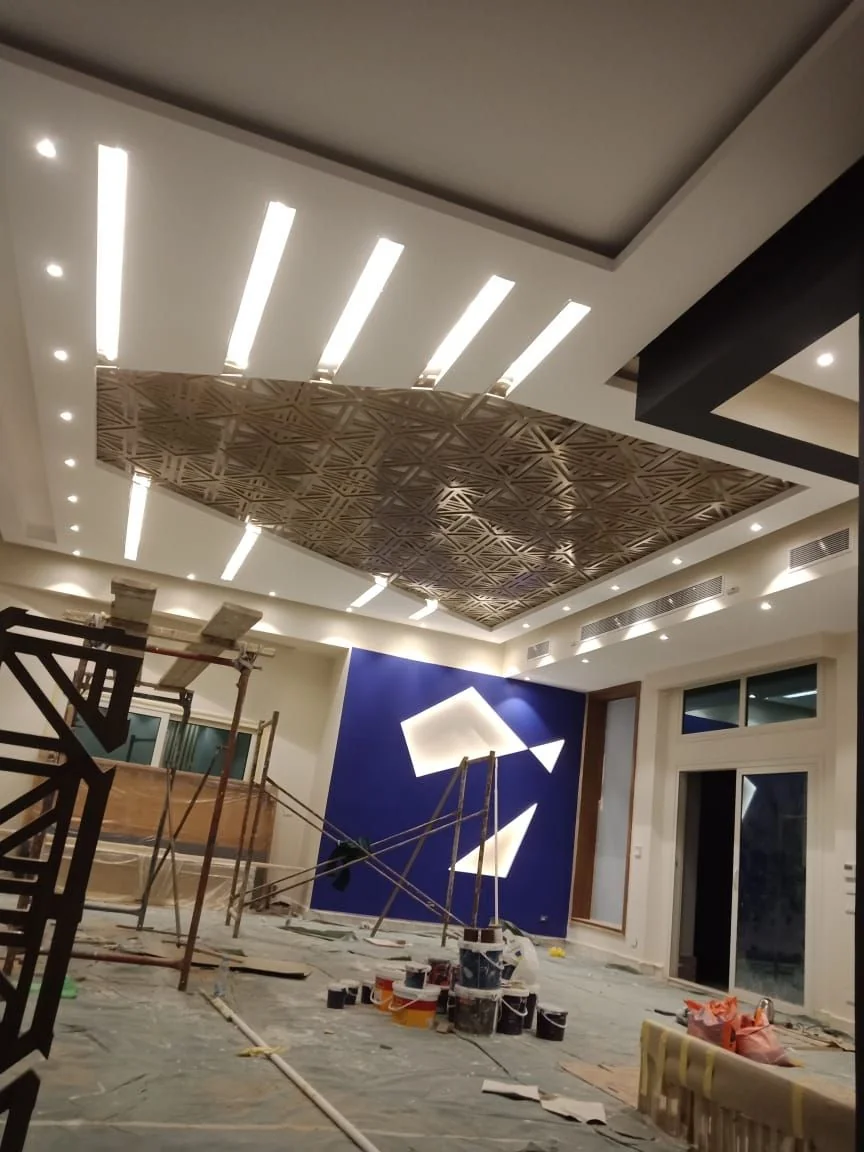 Intricate false ceiling design with blue accent wall painting services Dubai